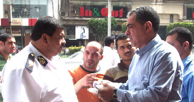 عاطف حسن عبدالفتاح أثناء حديثه مع ضابط الشرطة